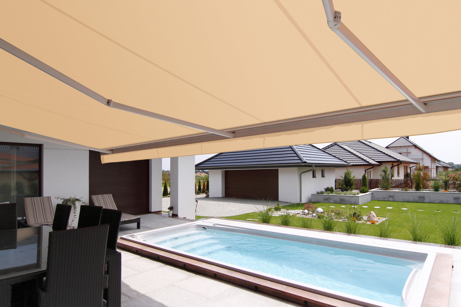 Modernt vitt hus med pool på baksidan. Altanen har en terrassmarkis med beige markisväv. Premium Markis.