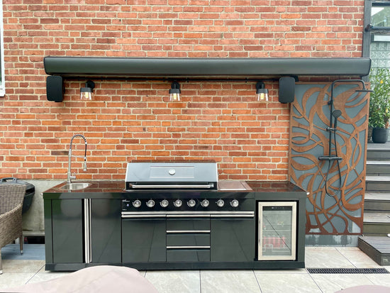 Svart Terrassmarkis Corsica med integrerad LED-belysning monterad som solskydd över uteköket.