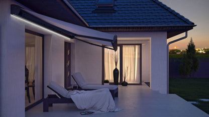 Modern terrassmarkis med integrerad LED-belysning på en uteplats vid skymning, markisen har svart konstruktion med ljus markisväv. Premium Markis, modell Corsica. premium-markis.se