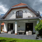 Robust, kvalitativ, grå terrassmarkis, markisen har grå silver RAL9006 konstruktion med ljusgrå markisväv. Monterad på en uteplats med stenplattor och gräsmatta. Premium Markis, modell Palladio. premium-markis.se