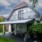 Robust, kvalitativ, grå terrassmarkis, markisen har grå silver RAL9006 konstruktion med ljusgrå markisväv. Monterad på en uteplats med stenplattor och gräsmatta. Premium Markis, modell Palladio. premium-markis.se