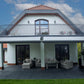 Robust, kvalitativ, grå terrassmarkis, markisen har grå silver RAL9006 konstruktion med ljusgrå markisväv. Monterad på en uteplats med stenplattor och gräsmatta. Premium Markis, modell Palladio. premium-markis.se